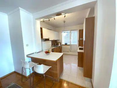a kitchen with a table and chairs in a room at Zaimov Penthouse with great view in Sofia