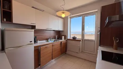 a kitchen with a white refrigerator and a window at Zaimov Penthouse with great view in Sofia