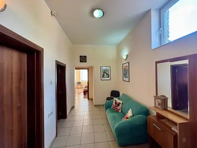 a living room with a green couch and a television at Comfy Apt next to Palace of Justice in Sofia