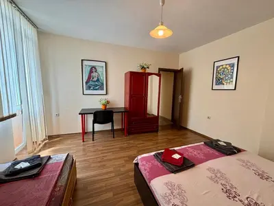 a room with two beds and a desk in it at Comfy Apt next to Palace of Justice in Sofia