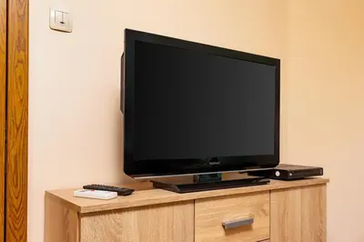 a flat screen tv sitting on top of a cabinet at Sunflower Studio next to Kolodrum Plovdiv in Plovdiv