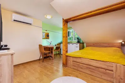a bedroom with a bed and a dining room at Sunflower Studio next to Kolodrum Plovdiv in Plovdiv