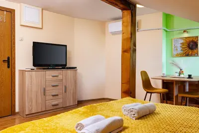 a bedroom with a tv and a bed with towels at Sunflower Studio next to Kolodrum Plovdiv in Plovdiv