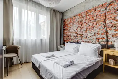 a bedroom with a brick wall and a bed at Splendid 1BDMApartment Near Shopping Mall & Metro in Sofia