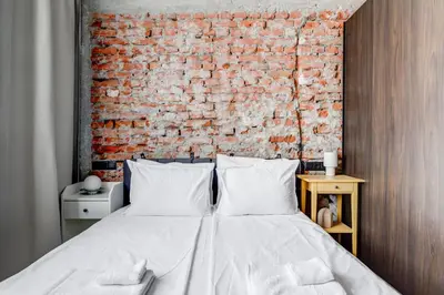 a bedroom with a brick wall and a bed at Splendid 1BDMApartment Near Shopping Mall & Metro in Sofia