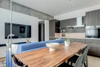 a kitchen and dining room with a wooden table and a blue couch at Splendid 1BDMApartment Near Shopping Mall & Metro in Sofia