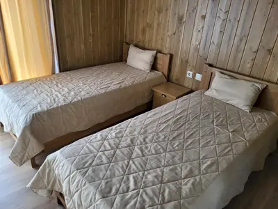 two beds in a room with wood paneling at Pirin Golf Villa Sokol in Bansko