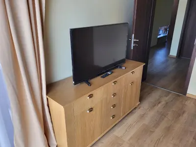 a flat screen tv sitting on top of a dresser at Pirin Golf Villa Sokol in Bansko