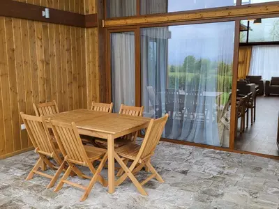 a wooden table and chairs in a room at Pirin Golf Villa Sokol in Bansko