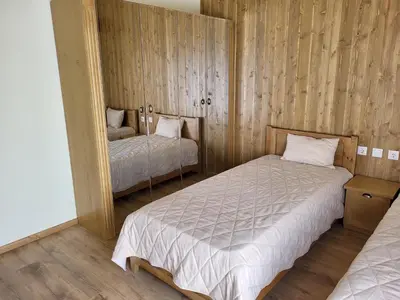 a bedroom with two beds and a mirror at Pirin Golf Villa Sokol in Bansko