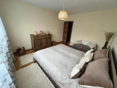a bedroom with a large bed and a dresser at Lovely cozy vintage apartment in Kyustendil