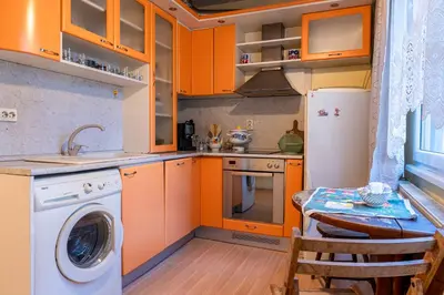 a kitchen with orange cabinets and a washing machine at The Lindens 1 Bedroom Cozy Apartment plus Free Parking!!! in Sofia