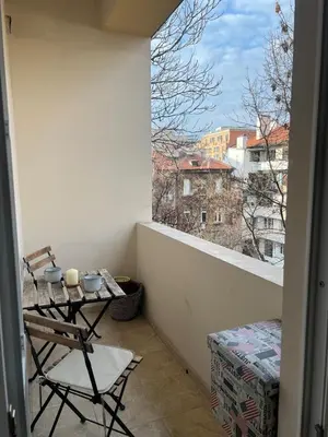 a balcony with a table and a view of a city at Spacious artsy apartment in Sofia