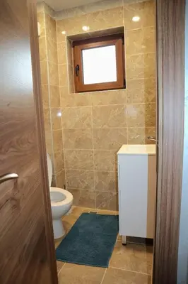 a bathroom with a toilet and a sink and a window at Nara in Pchelin