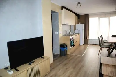 a living room with a flat screen tv and a kitchen at Nara in Pchelin