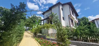 a house with a fence and some flowers at Nara in Pchelin