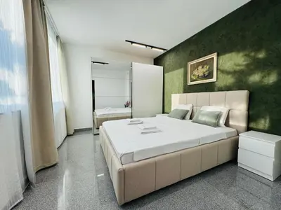 a bedroom with a large bed with a green wall at Green Accent Apartment in Sofia