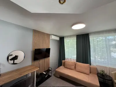 a living room with a couch and a flat screen tv at Green Accent Apartment in Sofia