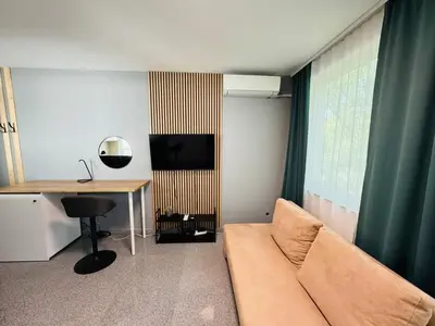 a living room with a couch and a desk at Green Accent Apartment in Sofia