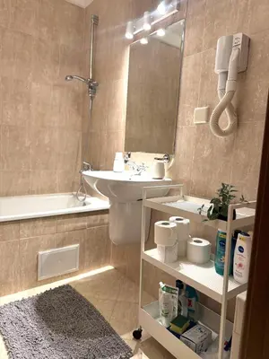 a bathroom with a sink and a toilet and a mirror at Pirin Golf Cozy Mountain Apartment with Views of Pirin & Rila in Bansko