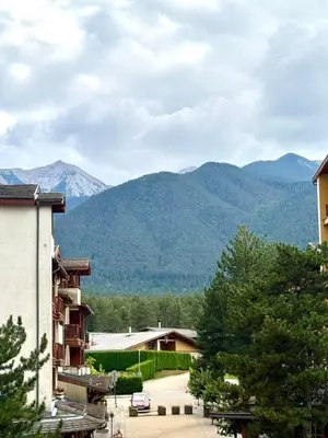 a view of the mountains from a house at Pirin Golf Cozy Mountain Apartment with Views of Pirin & Rila in Bansko