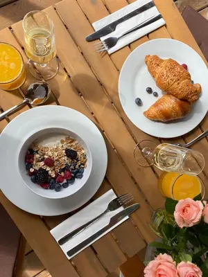 a table with a bowl of cereal and a plate of food at Pirin Golf Cozy Mountain Apartment with Views of Pirin & Rila in Bansko