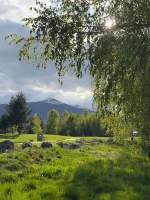 a view of a field with mountains in the background at Pirin Golf Cozy Mountain Apartment with Views of Pirin & Rila in Bansko
