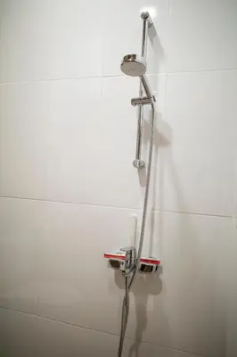 a shower in a white tiled bathroom at Yaninata Art House in Teteven in Teteven