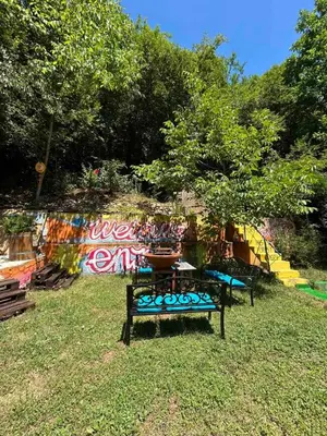 a park bench sitting in the grass with a table at Yaninata Art House in Teteven in Teteven