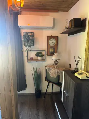 a room with a desk and a clock and a chair at Mountain Whisper Guesthouse in Smolyan