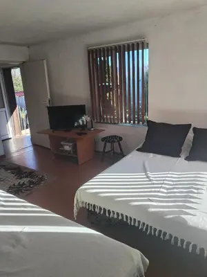 a bedroom with two beds and a tv and a table at Вила 