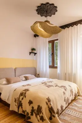 a bedroom with a large bed and a chandelier at Хижа Кукер - Арт Хижа за Вдъхновение и Отдих in Sofia