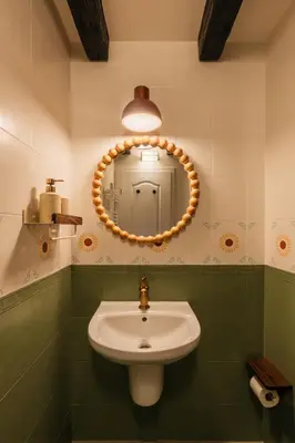 a bathroom with a sink and a circular mirror at Хижа Кукер - Арт Хижа за Вдъхновение и Отдих in Sofia