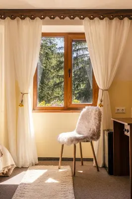 a room with a chair in front of a window at Хижа Кукер - Арт Хижа за Вдъхновение и Отдих in Sofia