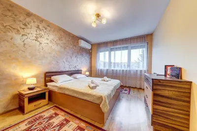 a bedroom with a large bed and a window at Bright retreat with Balcony & Mountain Views by Flat Manаger in Smolyan