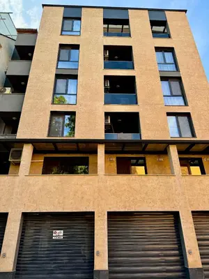 a tall building with two garage doors in front of it at Studio Sredec 77 in Plovdiv