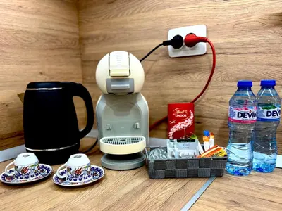 a coffee maker sitting on a table with plates and water at Studio Sredec 77 in Plovdiv