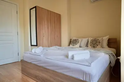 a large white bed with two towels on it at Apartment near a Metro Station in Sofia