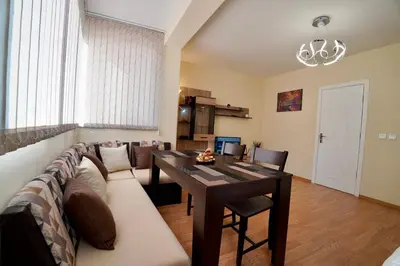 a living room with a long couch and a table at Apartment near a Metro Station in Sofia