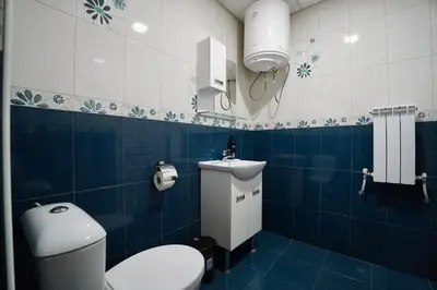 a blue and white bathroom with a toilet and a sink at Apartment near a Metro Station in Sofia
