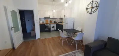 a kitchen and a living room with a table and chairs at SUPERsonicondo in Plovdiv