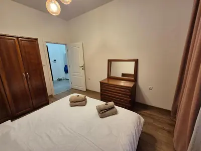 a bedroom with a bed and a dresser and a mirror at SUPERsonicondo in Plovdiv