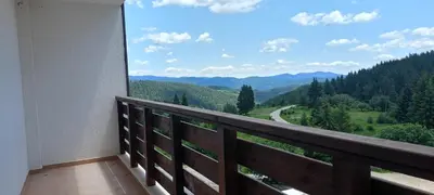 a balcony with a view of a road in the mountains at Apartment B35, complex Sokolitsite in Pamporovo