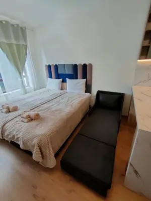 a bedroom with a large bed with a blue headboard at Apartment B34, complex Sokolitsite in Smolyan