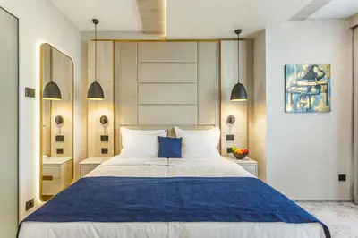a bedroom with a large white bed with blue sheets at East Plaza Hotel in Sofia