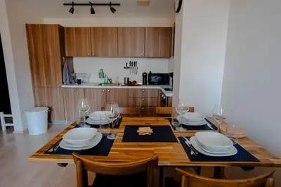 a dining room with a table with plates and wine glasses at Mountain View Sky Apartment Ori 4 in Sofia