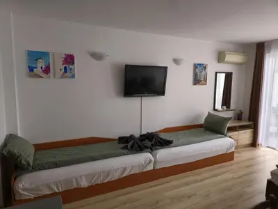 a bedroom with a bed with a television on the wall at Studio Kasandra in Hisarya