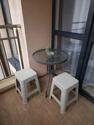 a table and two stools sitting next to a window at Studio Kasandra in Hisarya