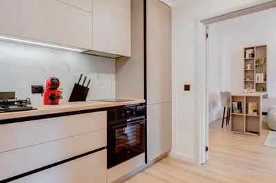 a kitchen with white cabinets and a stove top oven at City Gem 1BDRM 200m Sofia Statue in Sofia