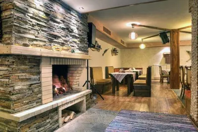 a living room with a stone fireplace with a table at Apart Hotel Forest Nook 3 Pamporovo in Pamporovo